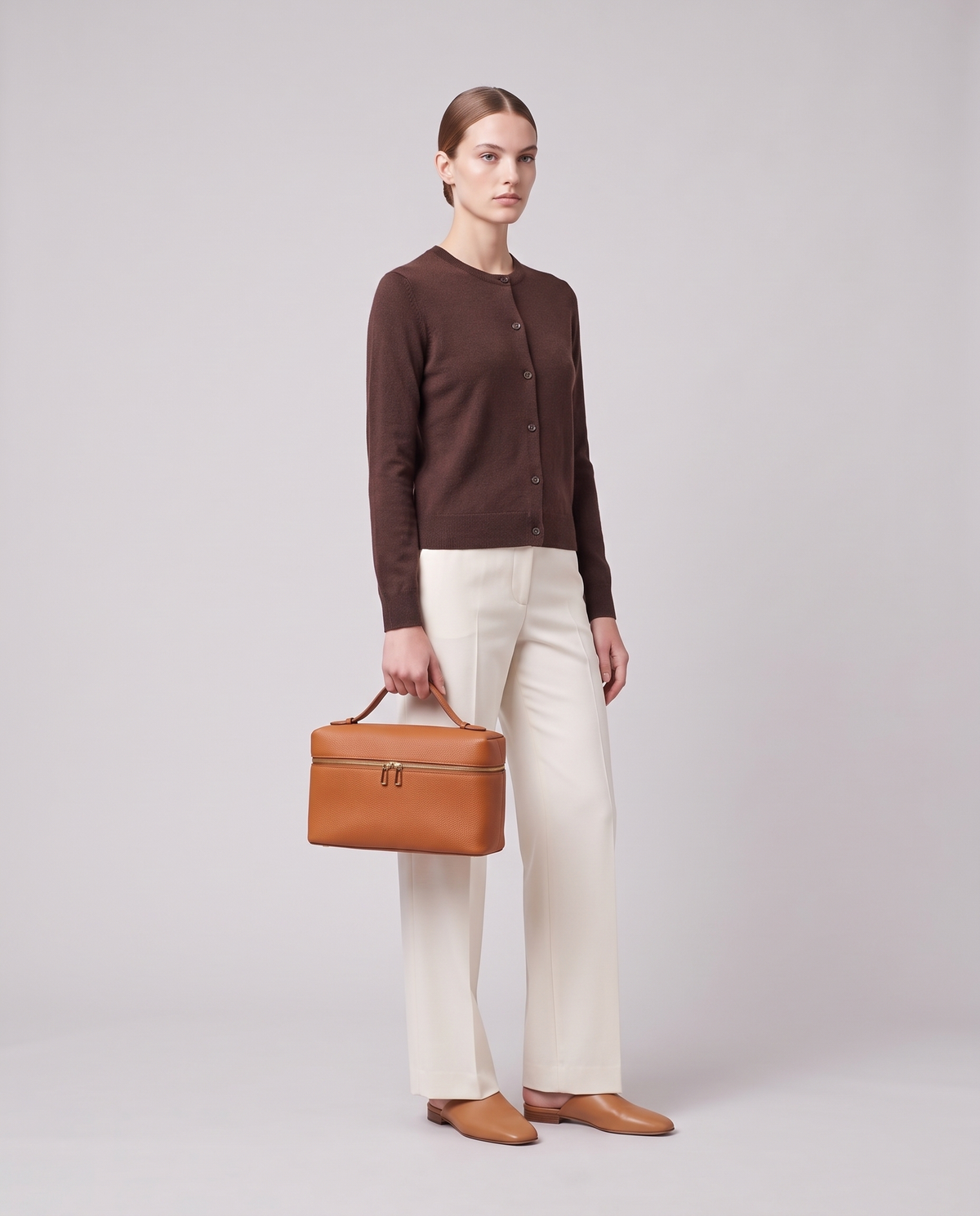 Model carrying the Orvieto vanity case in Cognac