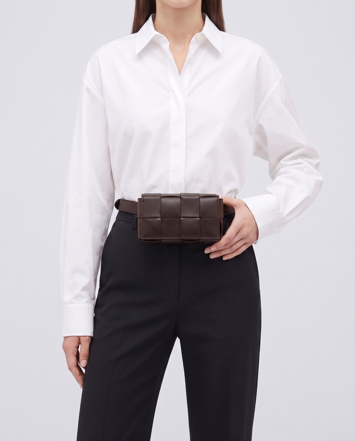 Cassette padded woven leather belt bag in Espresso – model wearing it at the waist