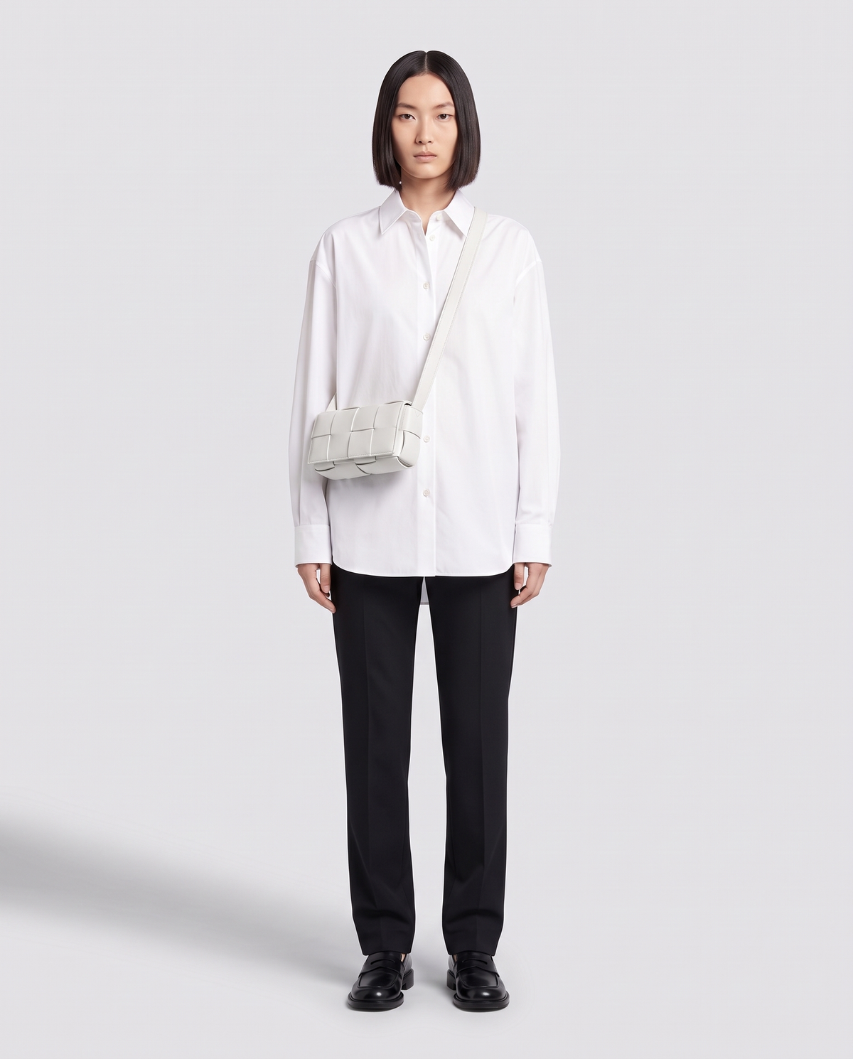 Cassette padded woven leather belt bag in Ivory – model wearing it crossbody, full length