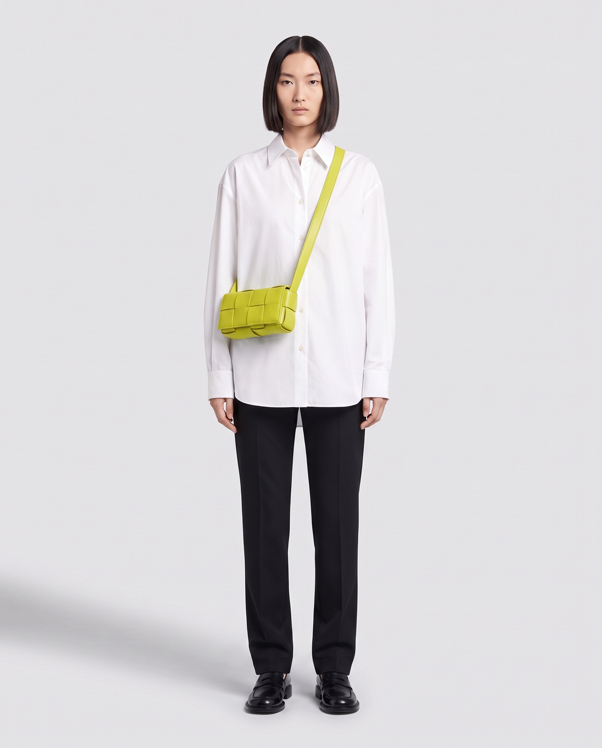 Cassette padded woven leather belt bag in Lime – model wearing it crossbody, full length