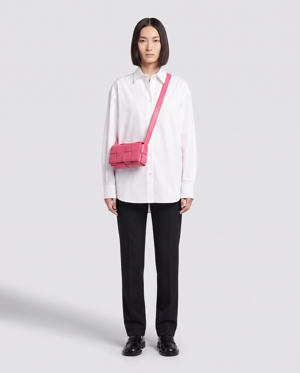 Cassette padded woven leather belt bag in Pink – model wearing it crossbody, full length
