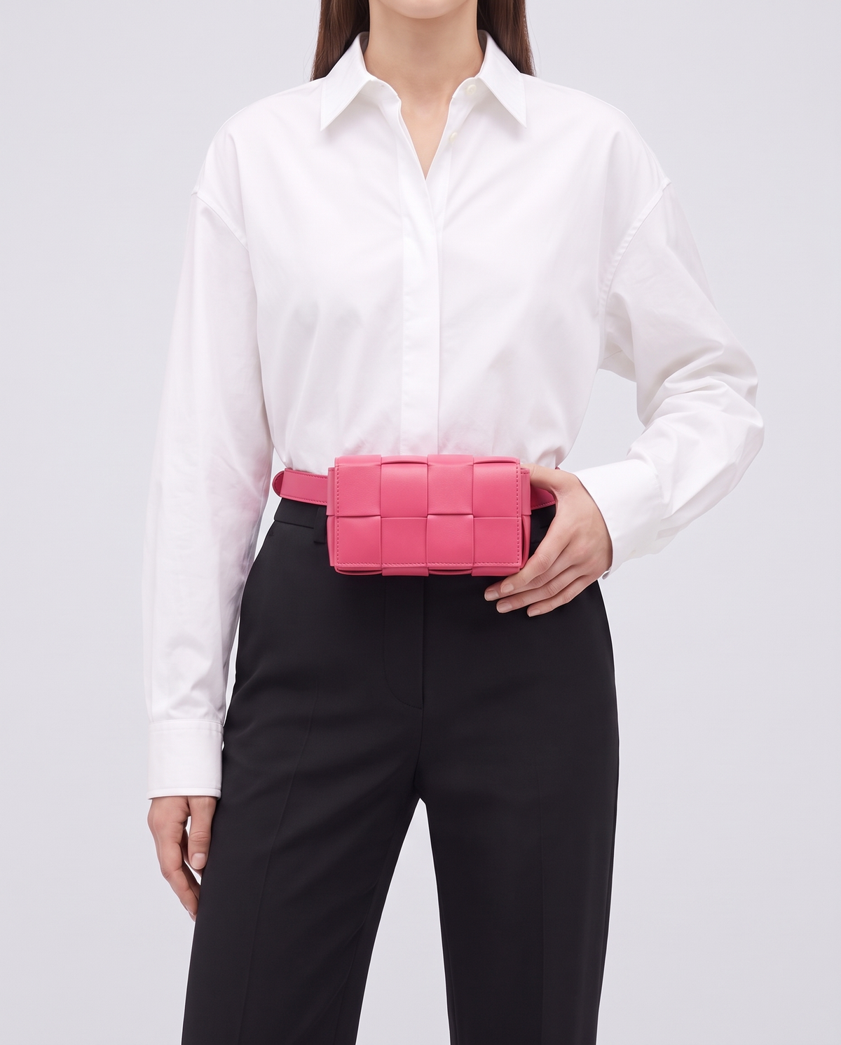 Cassette padded woven leather belt bag in Pink – model wearing it at the waist
