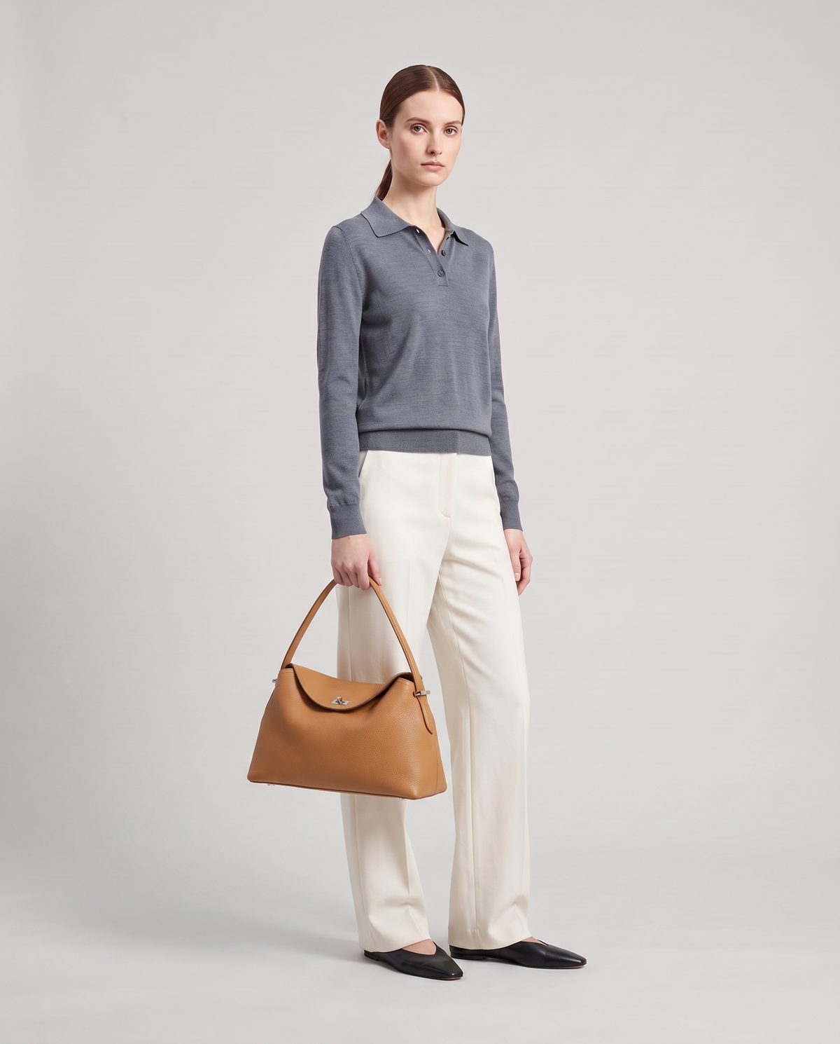 Model with the Porto pebbled leather top-handle bag in camel, full length