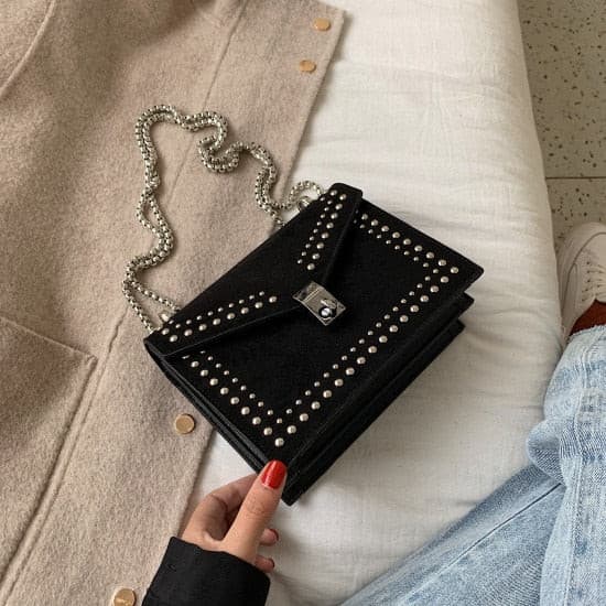 Girl carrying a black studded vegan leather bag