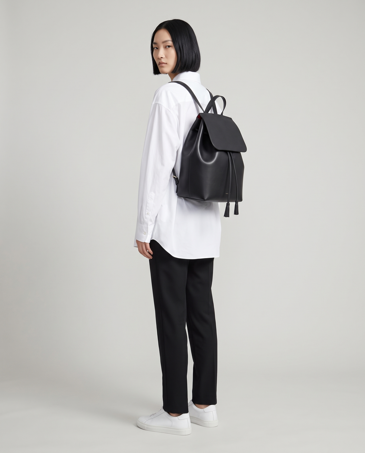 Roam Large leather backpack in Black – model wearing it on her back, full length