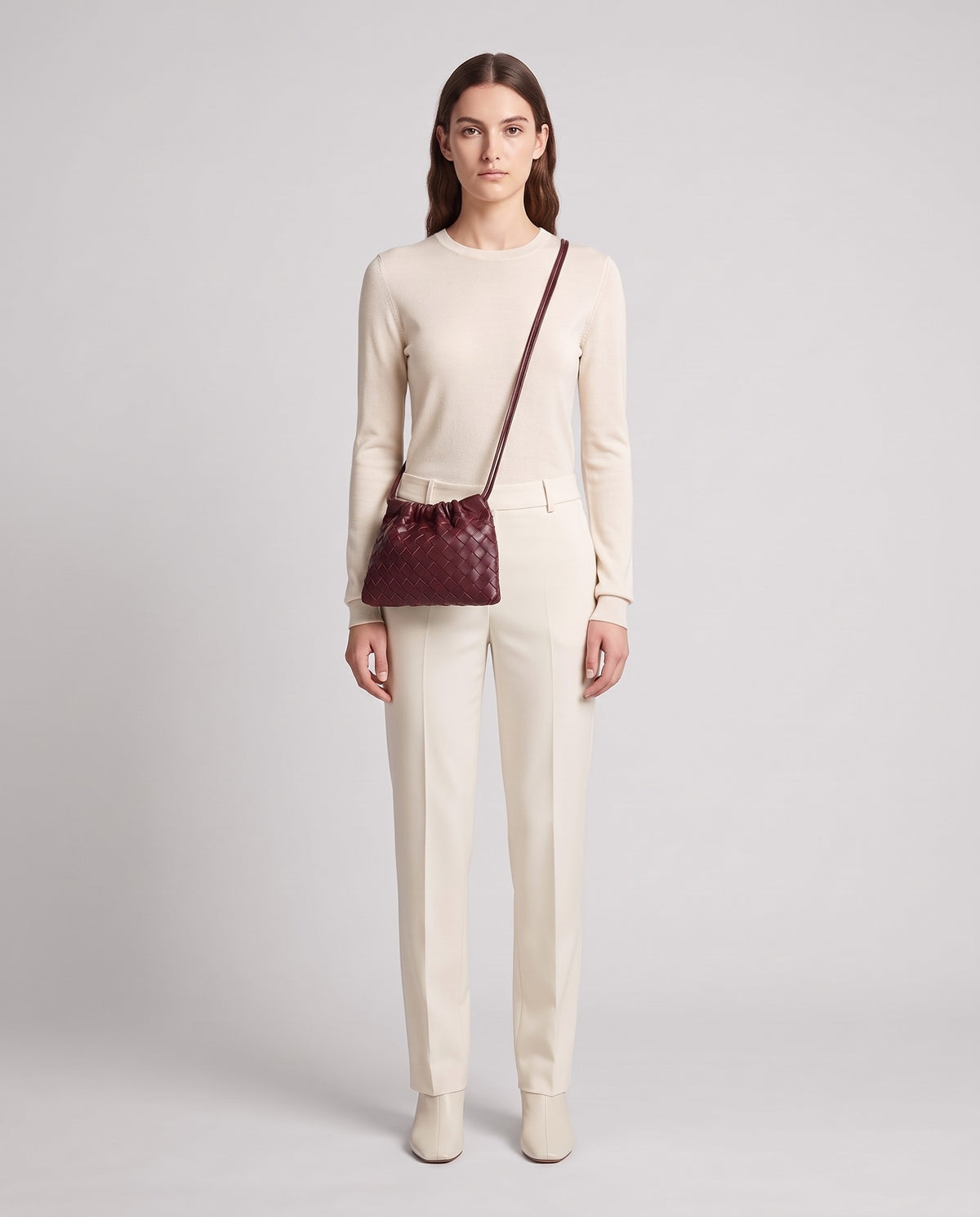 Model wearing the Serata woven leather clutch in Burgundy – full length