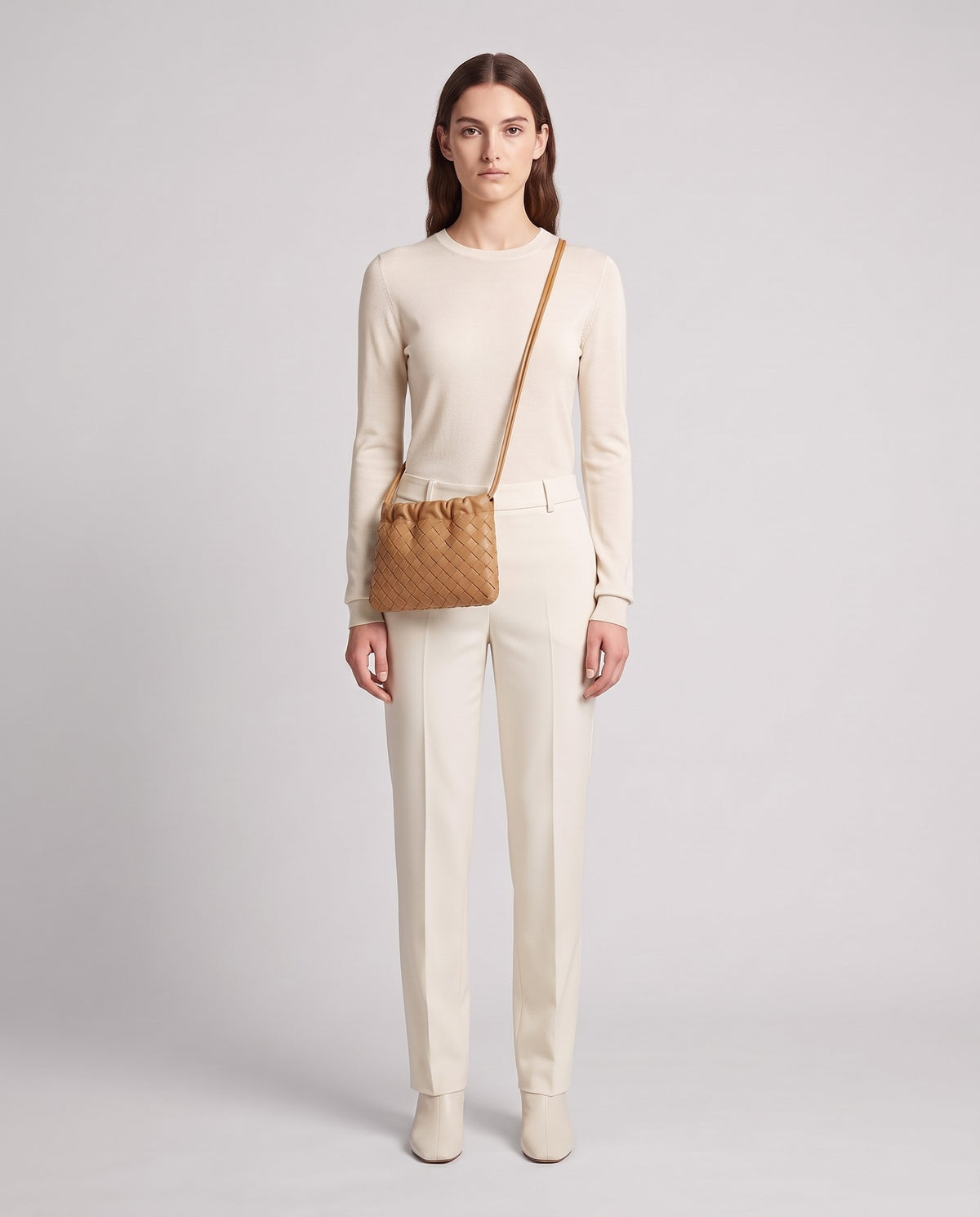 Model wearing the Serata woven leather clutch in Camel – full length