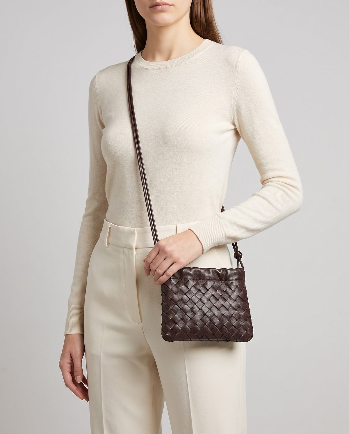 Serata woven leather clutch in Espresso – worn crossbody on model