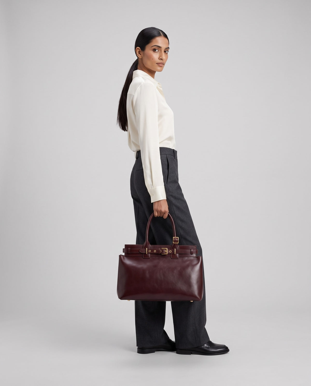 Model wearing the Spello top-handle bag in Burgundy – full-length view