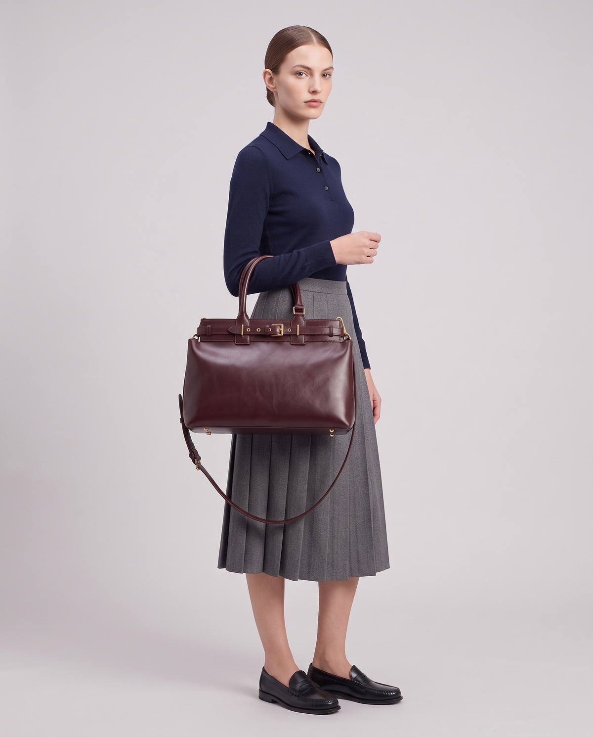 Model carrying the Spello top-handle bag in Burgundy