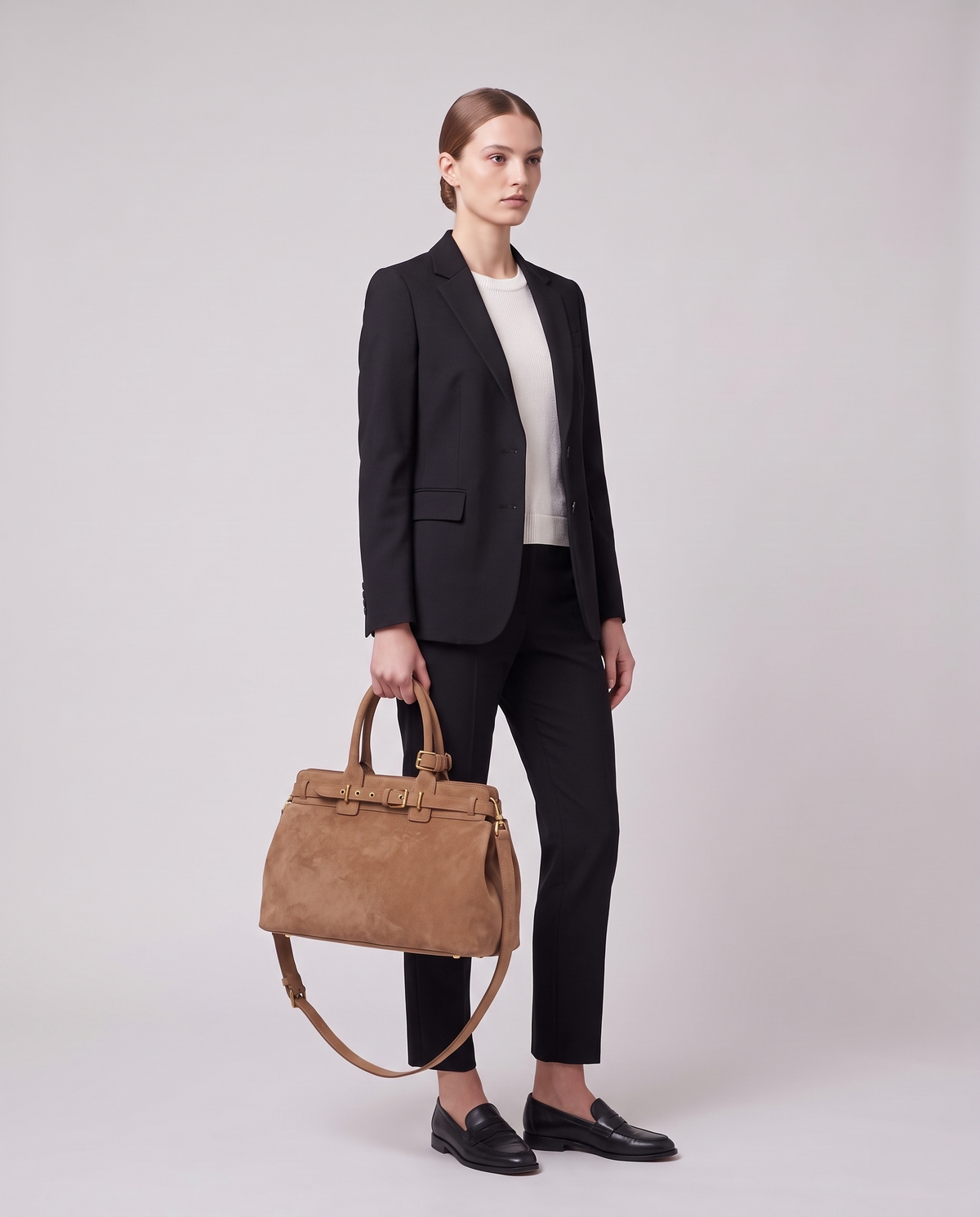 Model carrying the Spello top-handle bag in Taupe