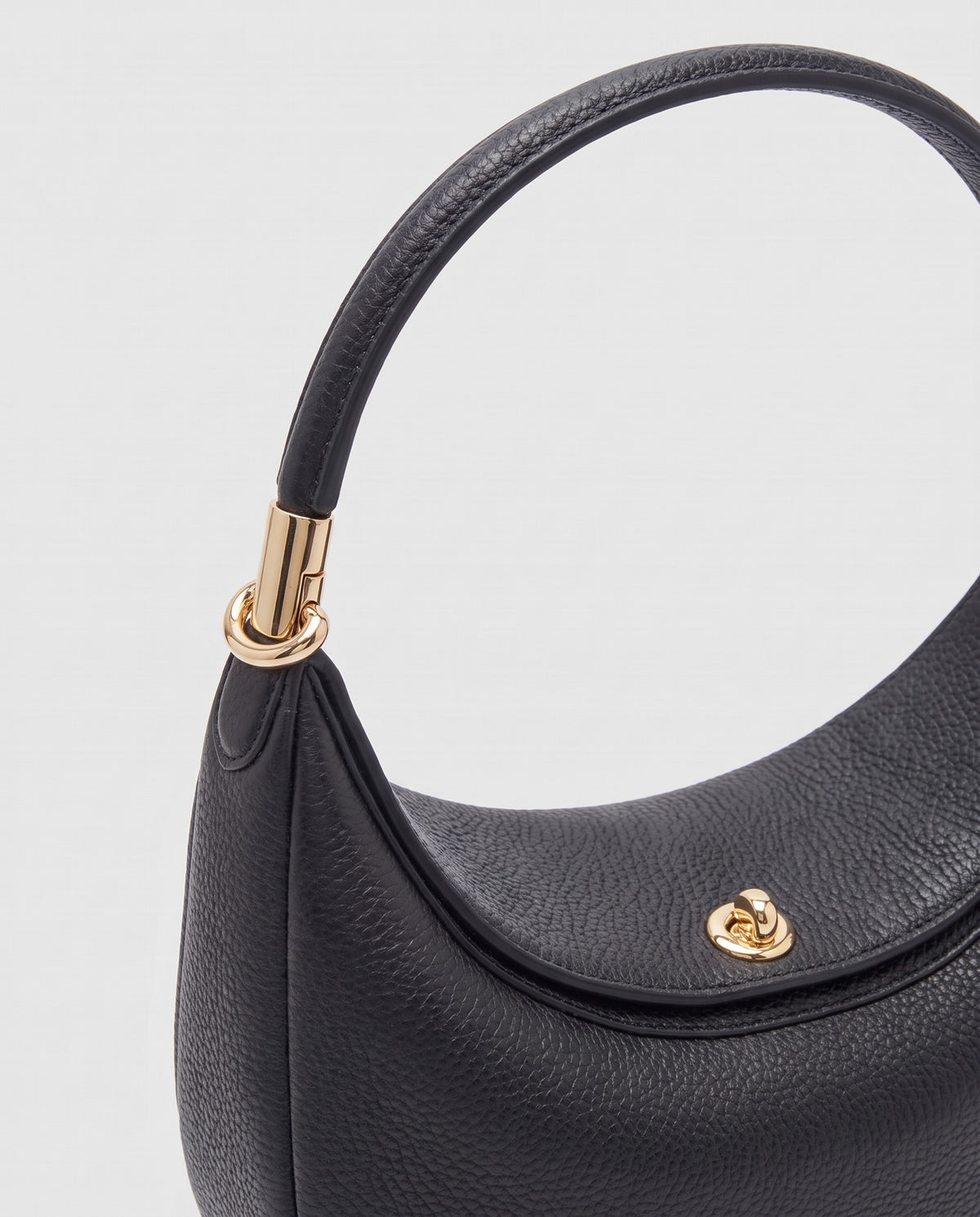 Gold clasp and handle collar detail on the Todi crescent bag in Black