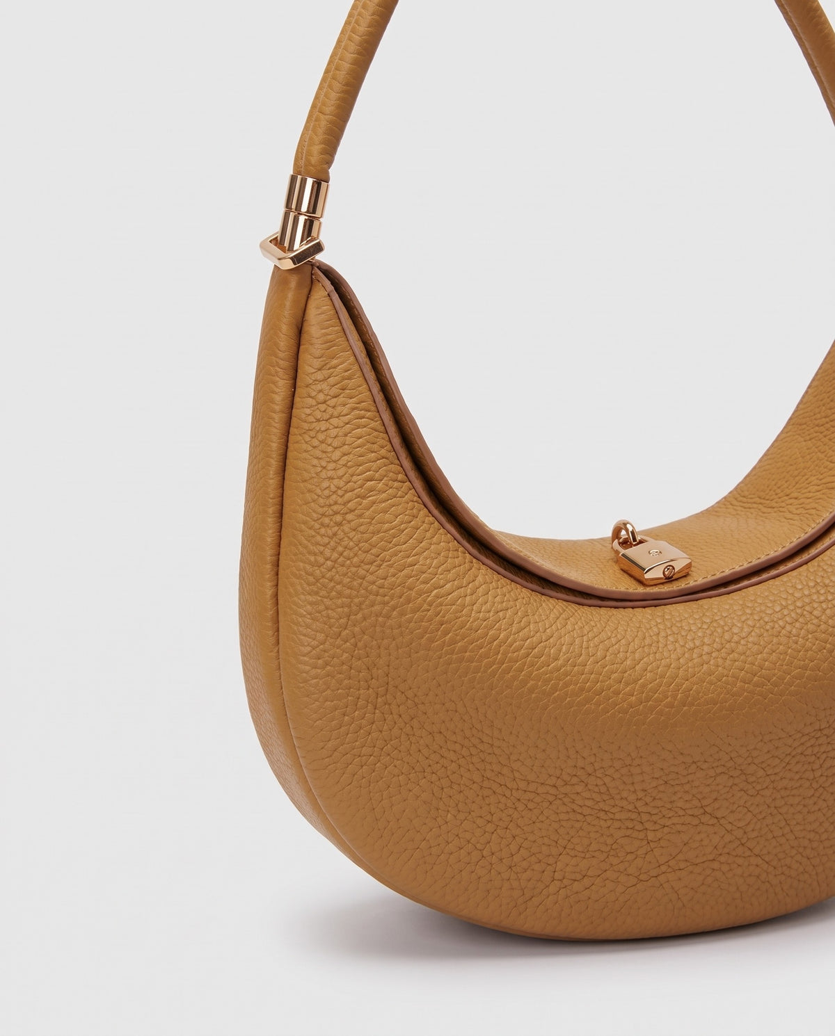 Gold clasp and handle collar detail on the Todi crescent bag in Caramel