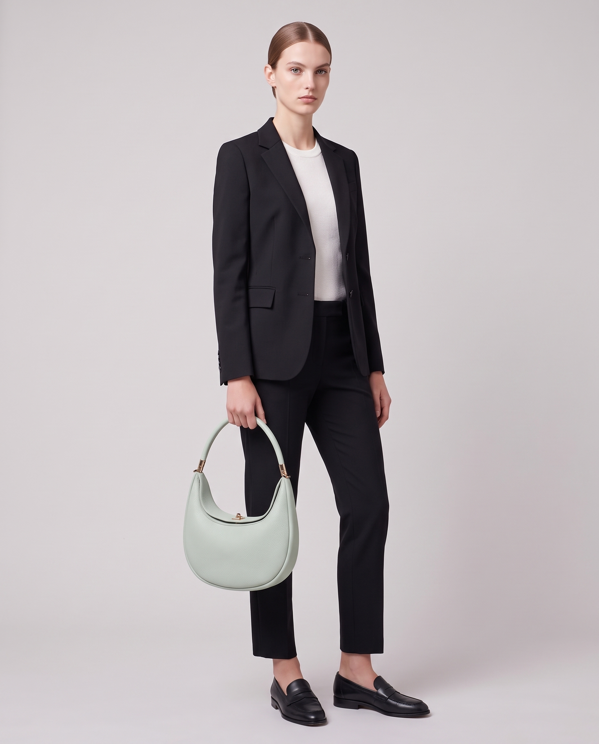 Model carrying the Todi crescent bag in Mint