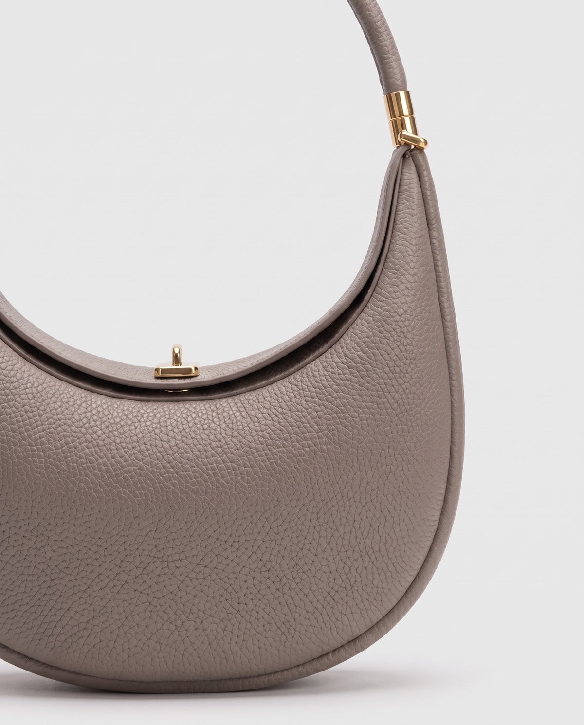 Gold clasp and handle collar detail on the Todi crescent bag in Taupe