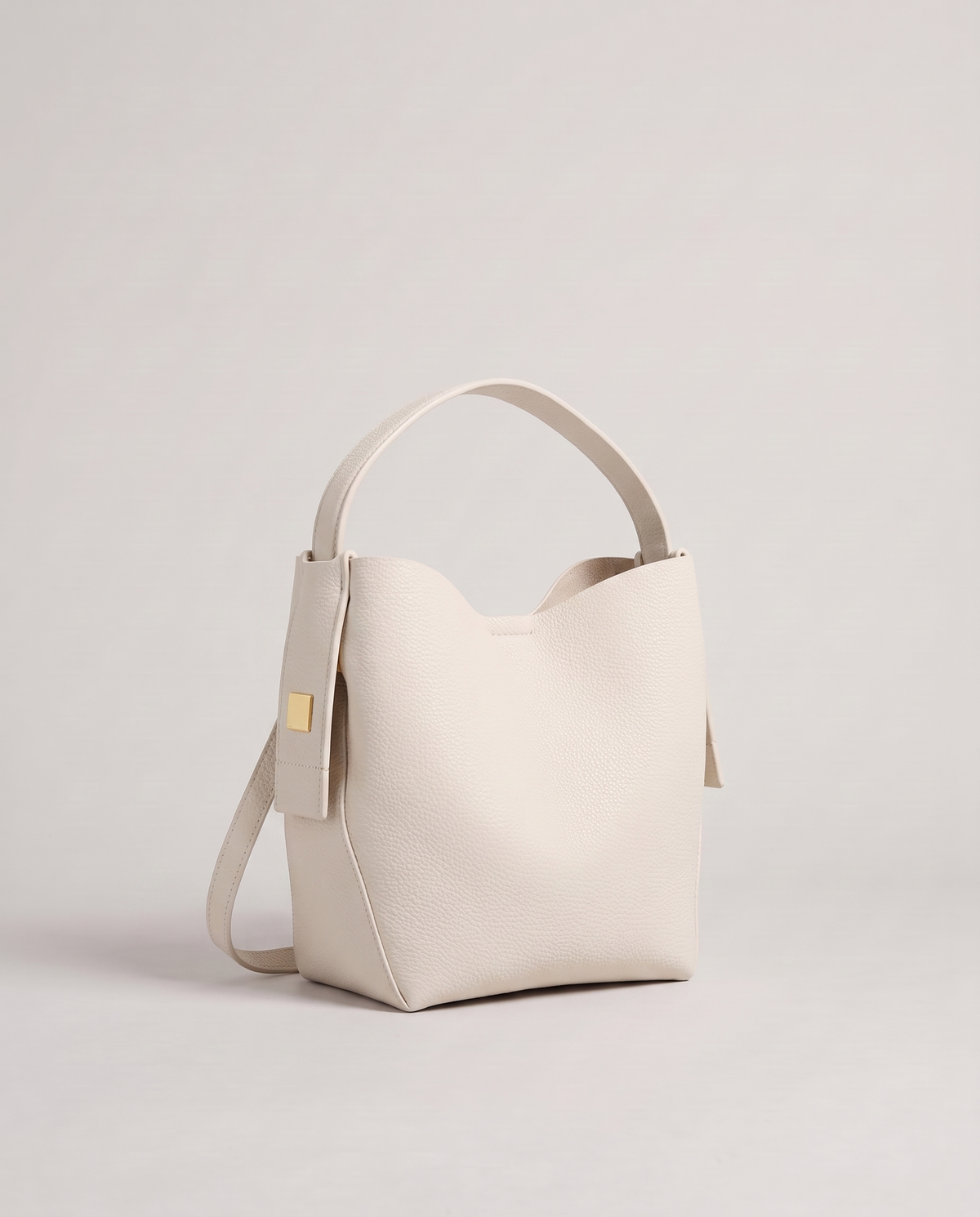 Transit leather bucket bag in Chalk – three-quarter view