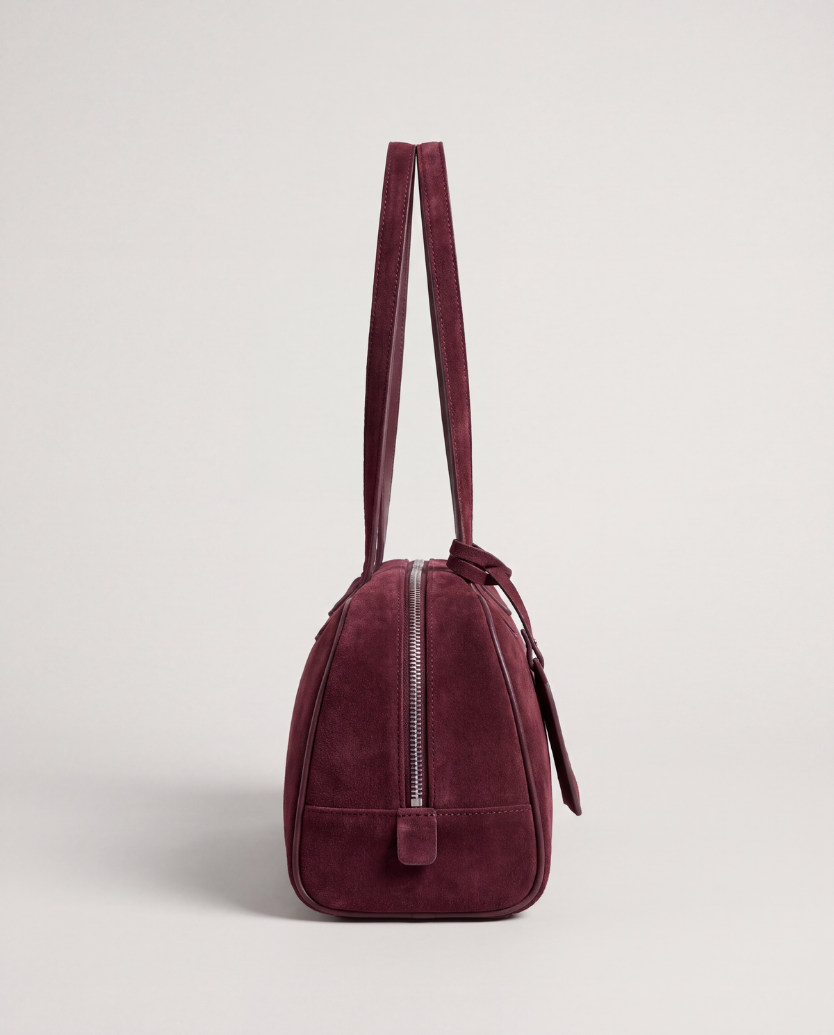 Valentina Linea suede shoulder bag in Burgundy, side view showing the end zip