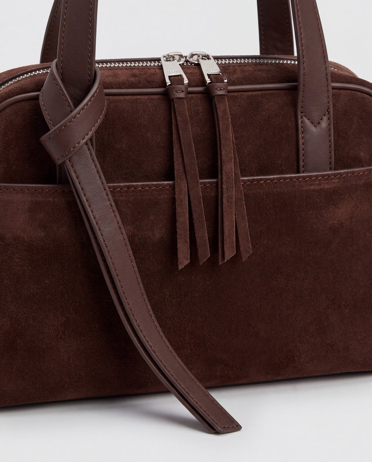Detail of the knotted strap, double silver zips and suede pulls on the Valentina Linea bag in Chocolate