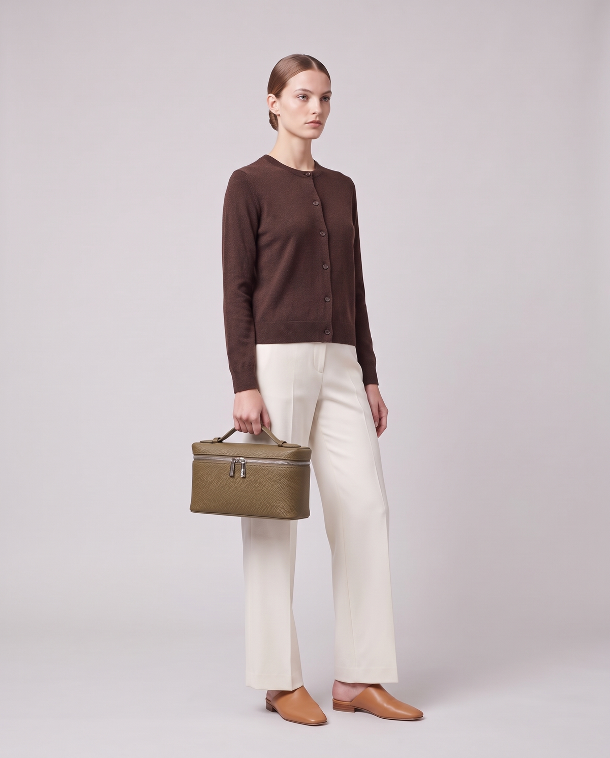 Model carrying the Valentina Orvieto Small top-handle bag in Taupe leather