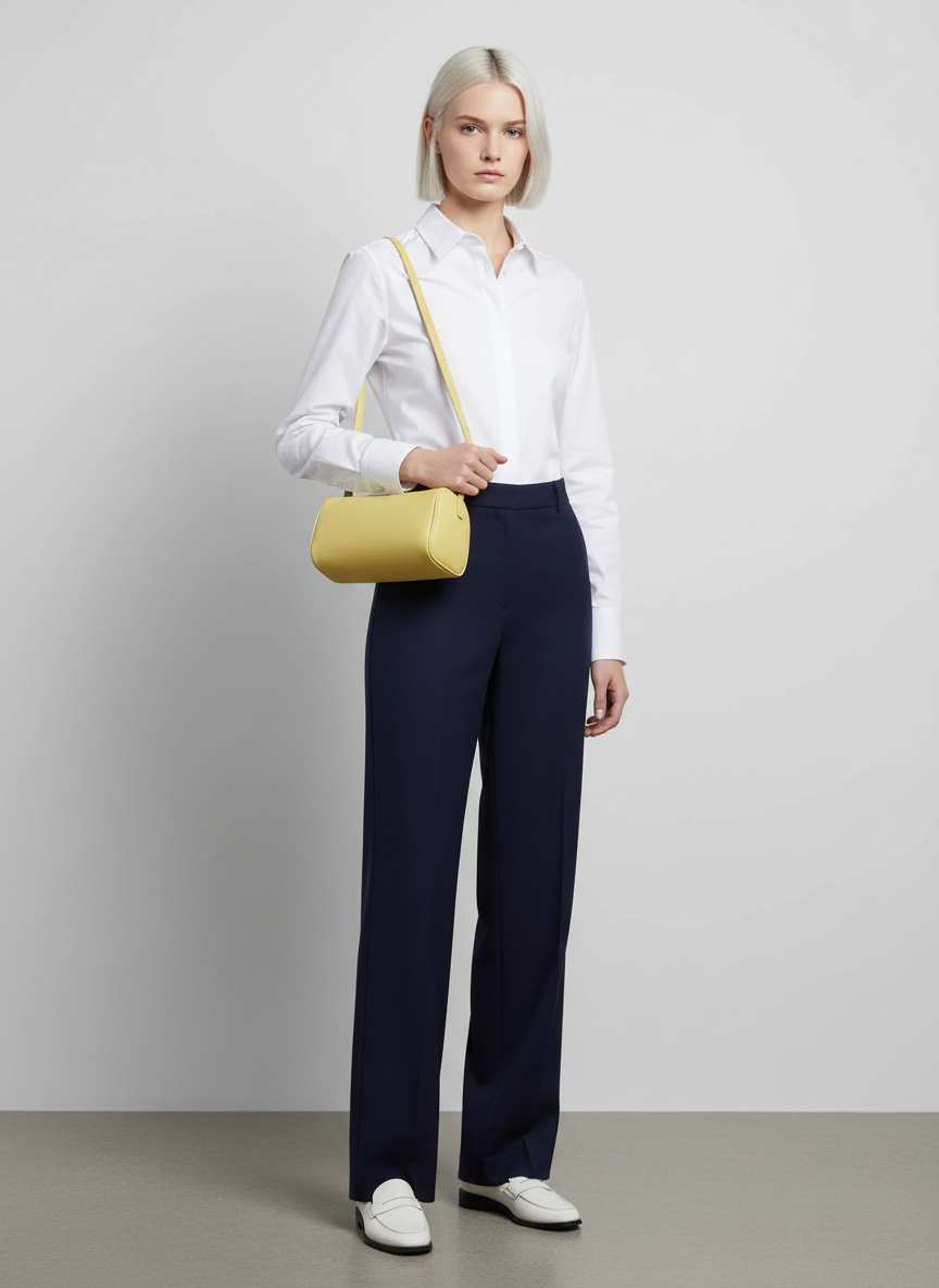 Model carrying the Valentina Roma barrel bag in pale yellow leather, full length