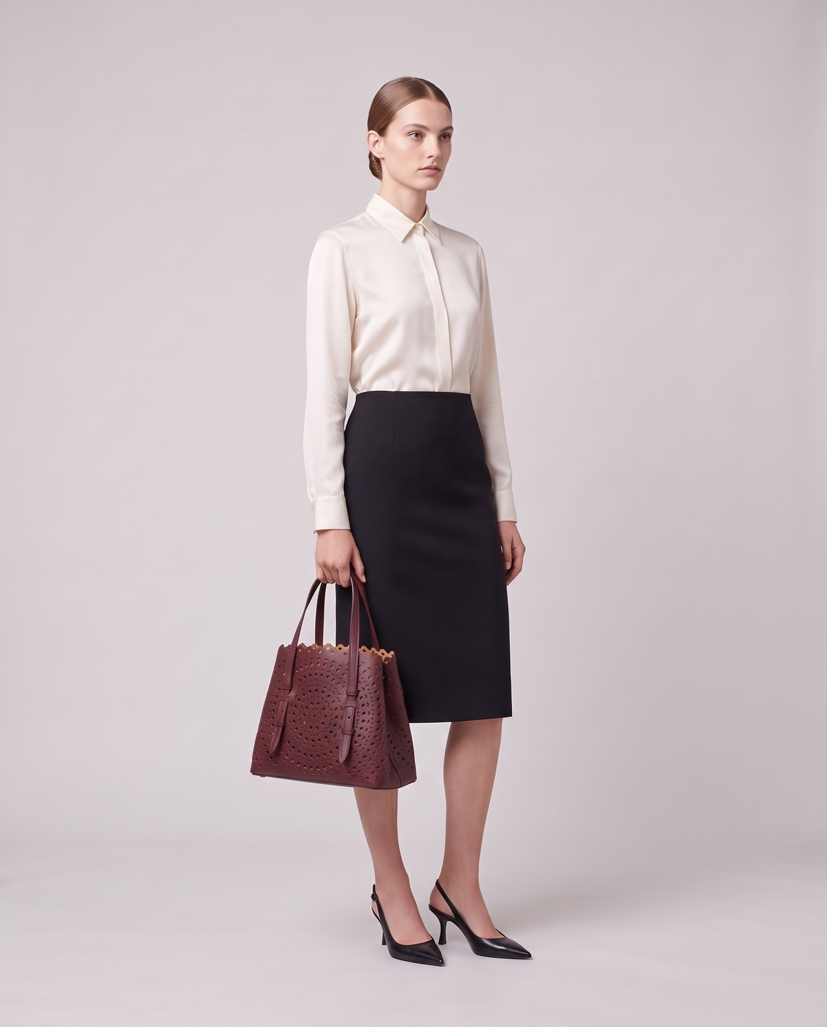 Model holding the Valentina Urbino Small bag in Burgundy, full length